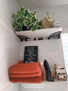 a shelf with towels and a plant on it at Shauna's house in Poole +4 photos