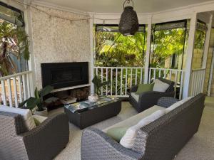 a screened in porch with couches and a fireplace at Beach Haven in Bunbury