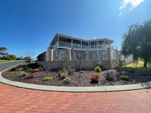 a house with a flower garden in front of it at Beach Haven in Bunbury