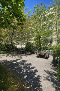 a park with benches and trees in front of a building at Danish style apartment in Copenhagen +8 photos