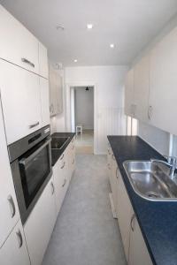 a kitchen with white cabinets and a sink at Danish style apartment in Copenhagen