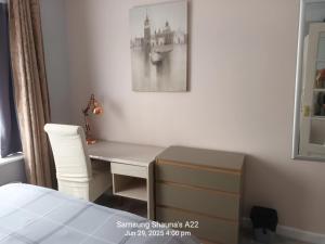 a bedroom with a desk with a chair and a bed at Shauna's house in Poole
