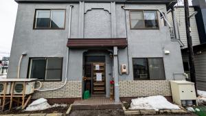 a house with the front door of it at Tokachi Base Camp in Kami-furano