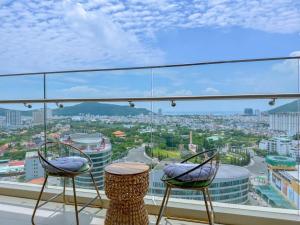 a balcony with two chairs and a view of a city at The Song Luxury Near Beach Apartment - Căn hộ Nghỉ Dưỡng Cao Cấp Cạnh Biển - Moonlight Homestay in Vung Tau