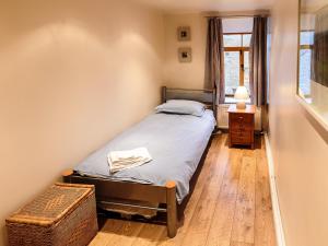 a small bedroom with a bed and a window at Millstone Cottage in Bradwell