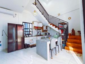 a kitchen with a counter and a staircase at Joy Pool House in Kuta