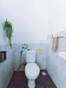 a bathroom with a white toilet and a sink at Joy Pool House in Kuta +10 photos