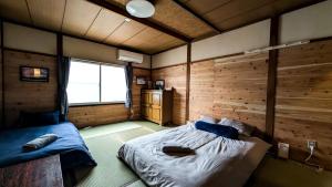 a bedroom with a bed in a room with wooden walls at Tokachi Base Camp in Kami-furano