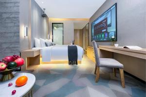 a hotel room with a large bed and a desk at 啡诺艺术美居 in Guangzhou +85 photos