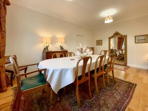 a dining room with a table and chairs and a mirror at Grieves Cottage - Uk50908 in Cupar