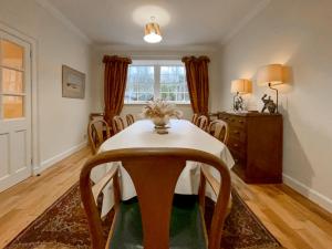 a dining room with a table and chairs and a window at Grieves Cottage - Uk50908 in Cupar