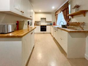 a kitchen with white cabinets and a counter top at Grieves Cottage - Uk50908 in Cupar