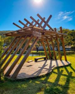 a wooden pavilion in a park in the grass at Chalé das águas in Cunha