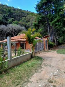 a house with a fence next to a dirt road at Chalé das águas in Cunha