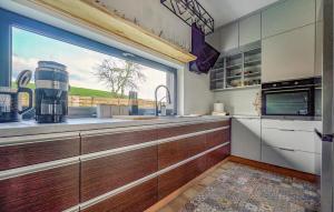 a kitchen with a large window and a kitchen counter at Beautiful Home In Ostrowite With Lake View in Ostrowite