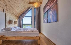 a bedroom with a bed and a large window at Beautiful Home In Ostrowite With Lake View in Ostrowite +16 photos