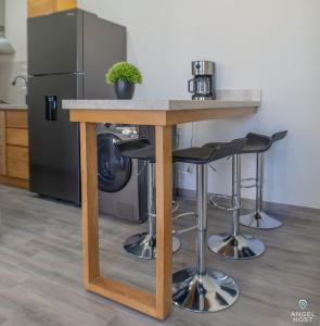 a kitchen with a island with bar stools at Pool BBQ & a Short Walk to the Malecon in La Paz