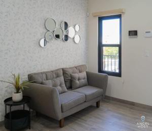 a living room with a couch and mirrors on the wall at Pool BBQ & a Short Walk to the Malecon in La Paz