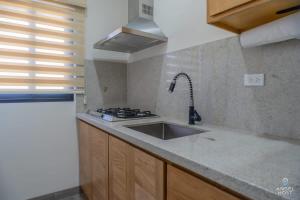 a kitchen with a sink and a stove at Pool BBQ & a Short Walk to the Malecon in La Paz +15 photos