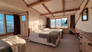 a bedroom with two beds in a room with windows at Kaha Lodge in Rangataua