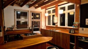 a kitchen with wooden cabinets and a counter with windows at Kaha Lodge in Rangataua +33 photos