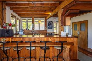 a kitchen with a counter with stools at a bar at Kaha Lodge in Rangataua