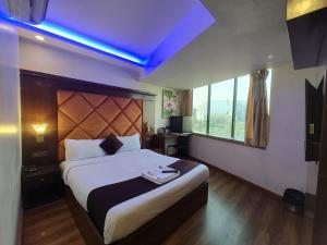 a bedroom with a large bed with a blue light at Hotel Rio in Mumbai