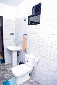 a white bathroom with a toilet and a sink at Ella Breathing Space in Ella