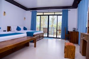 a bedroom with two beds and a large window at Ella Breathing Space in Ella