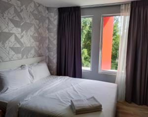 a bedroom with a white bed with a window at SRITEL BOUTIQUE HOTEL in Shah Alam