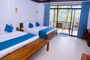 a bedroom with two beds and a balcony at Ella Breathing Space in Ella +31 photos