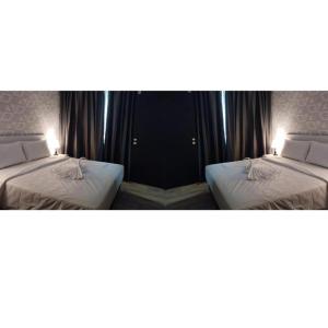 two beds in a room with two lamps on them at SRITEL BOUTIQUE HOTEL in Shah Alam +12 photos