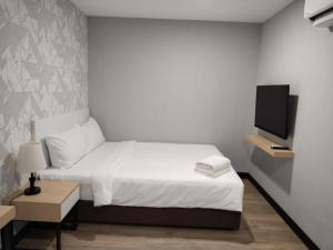 a bedroom with a bed and a tv on a wall at SRITEL BOUTIQUE HOTEL in Shah Alam