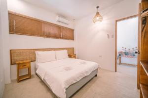 a bedroom with a large bed and a night stand at Villa Ramira in General Luna