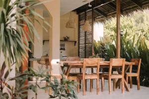 a dining room with a wooden table and chairs at Villa Ramira in General Luna
