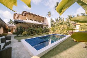 a villa with a swimming pool in front of a house at Villa Ramira in General Luna