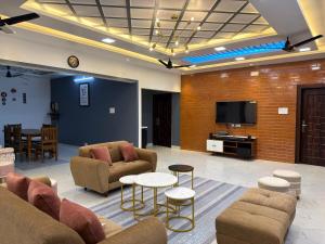 a living room with couches and a flat screen tv at Yelagiri castle in Yelagiri