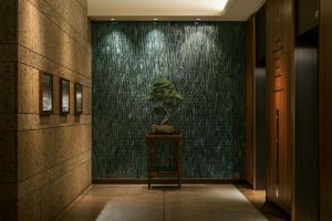 a plant on a table in a hallway with a wall at THE AOYAMA GRAND HOTEL in Tokyo