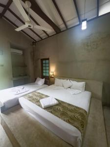 a bedroom with two beds and a ceiling at Sayon River Cottage in Wellawaya
