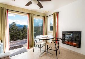 a living room with a table and a fireplace at Pikes Peak Paradise Bed and Breakfast in Woodland Park