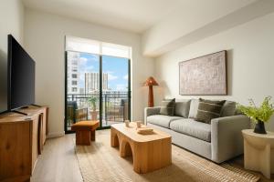a living room with a couch and a tv at Sense28 Edgewater, an AvantStay Hotel in Miami