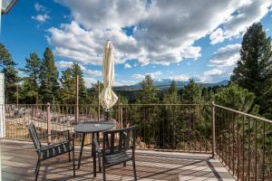 a patio with a table and chairs and an umbrella at Pikes Peak Paradise Bed and Breakfast in Woodland Park