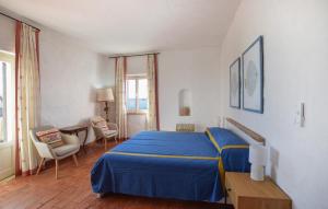 a bedroom with a blue bed and a table and chairs at Villa Antica in Stalettì
