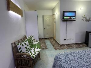 a room with a couch and a tv on a wall at House Jardin Del Caribe in Las Terrenas