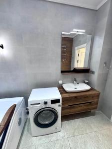 a bathroom with a washing machine and a sink at Boulevard in Samarkand