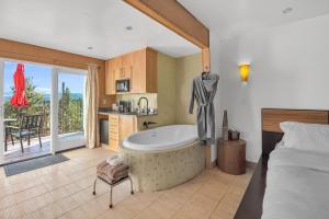 a bathroom with a tub and a bed and a kitchen at Pikes Peak Paradise Bed and Breakfast in Woodland Park