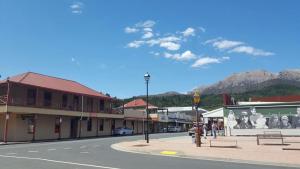 a street in a town with mountains in the background at Mt Lyell Motor Inn - By Orangepete in Queenstown