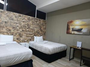 a room with two beds and a painting on the wall at Kartagus Centric in San Salvador
