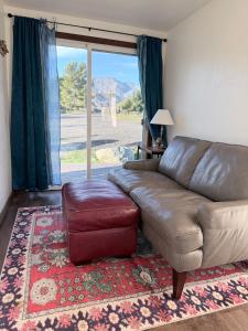 a living room with a leather couch and a stool at Private Ranch Retreat in Banning