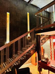 a room with a wooden staircase with a table at Macondo Hotel Galería in San Luis Potosí